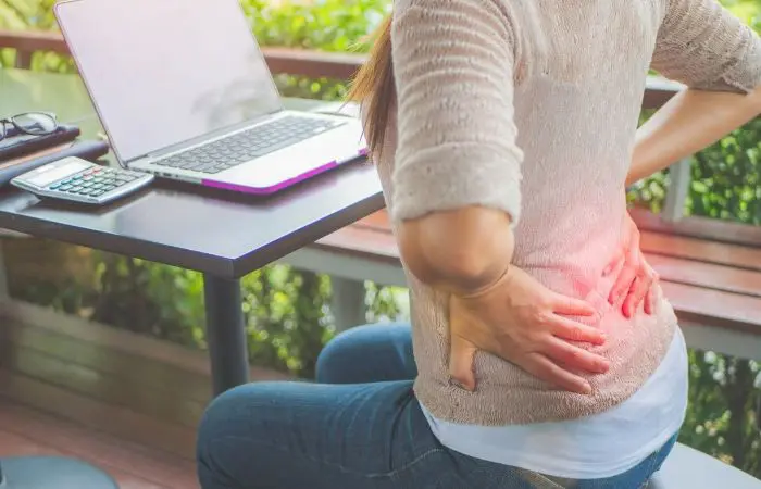 A person sitting on the ground with their hands in their pockets.