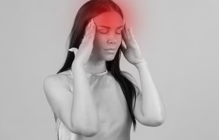 A woman holding her head in front of her face.