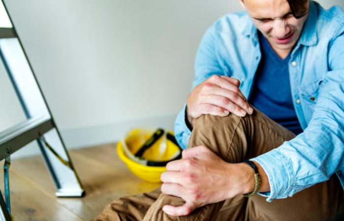 A man sitting on the floor with his hands in his pockets.