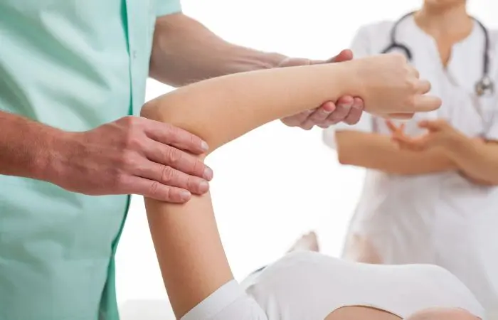 A person is getting their arm examined by an osteopath.